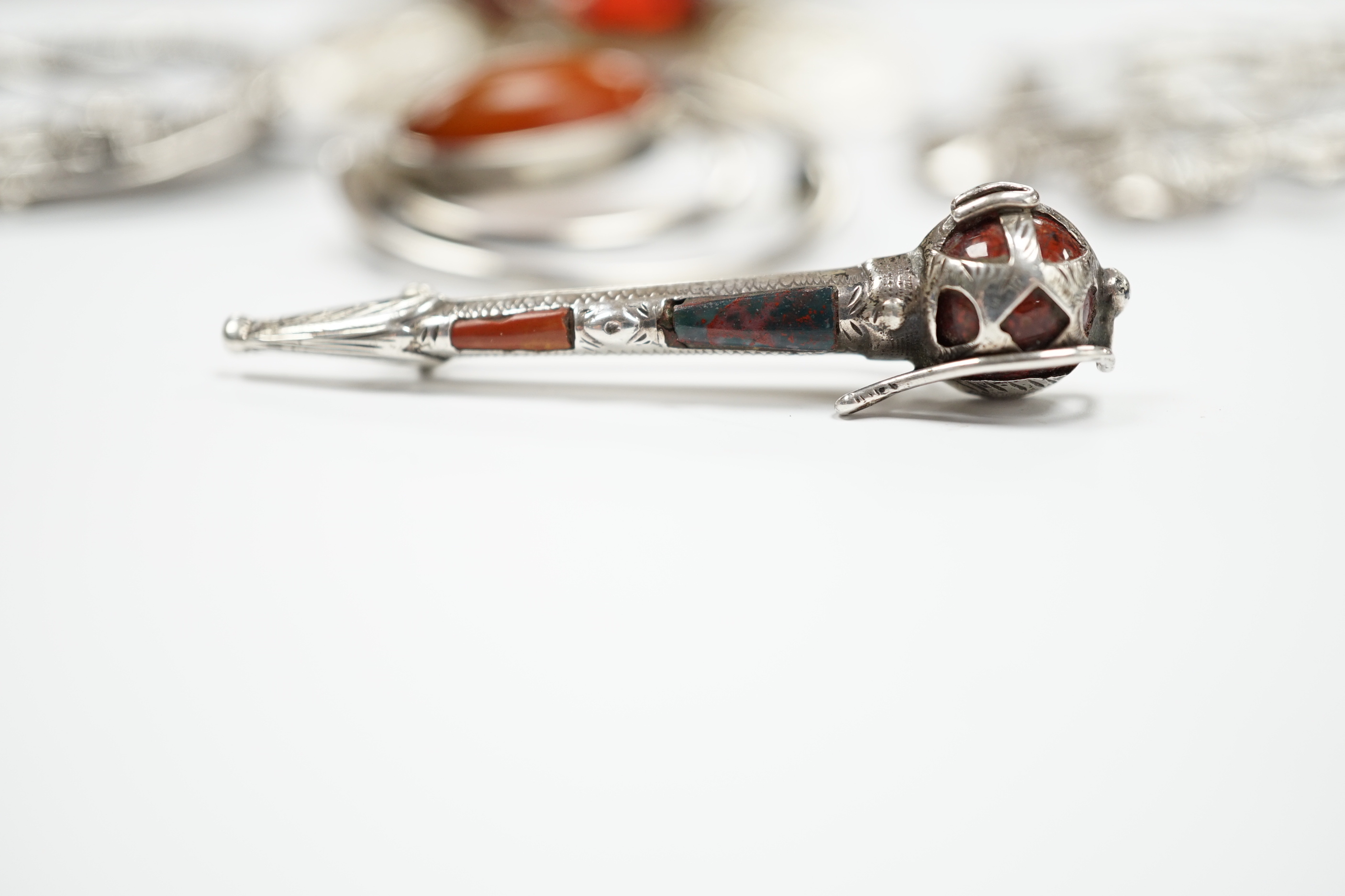 A 1950's Scottish silver and citrine coloured paste set circular brooch, 68mm, an Edwardian silver Celtic style brooch and three other white metal brooches, including Scottish hardstone set.